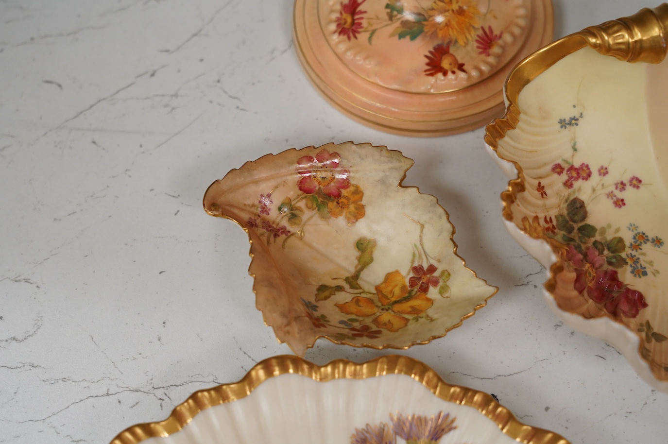 A pair of Royal Worcester blush ivory candlesticks, three bon bon dishes and a pair of plates, tallest 20cm. Condition - mostly good, some damage